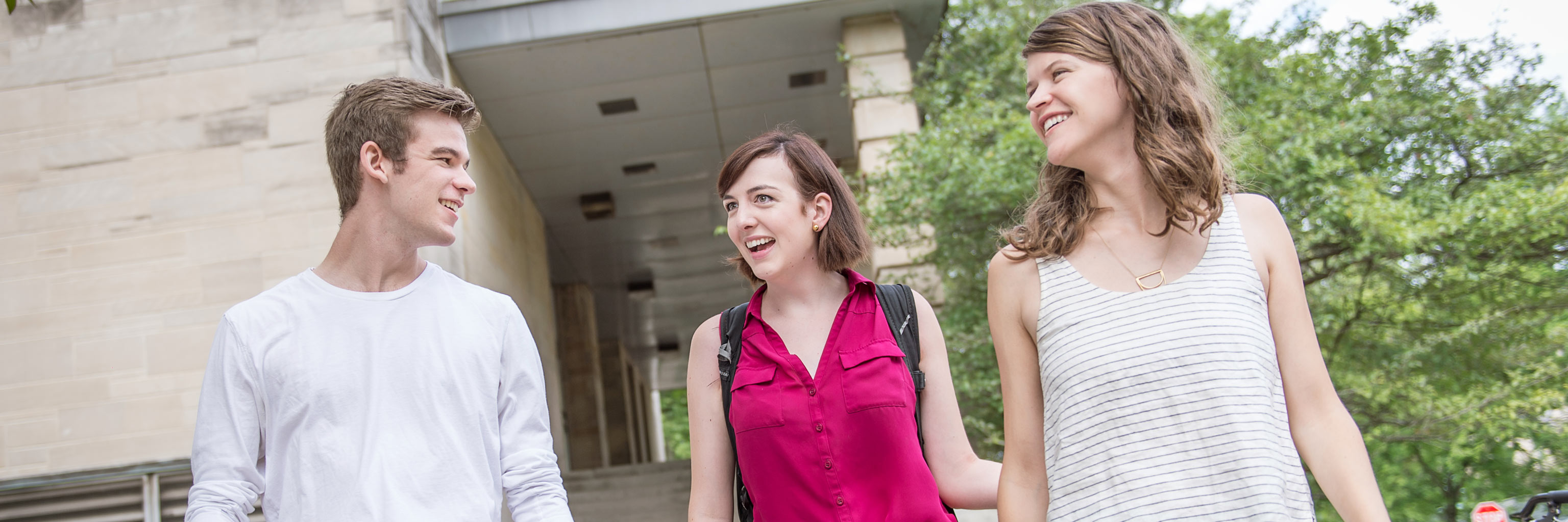 Three happy students walking outside of Ballantine Hall
