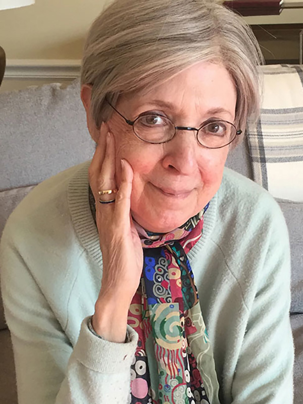 A headshot of Professor Emerita Susan Gubar, who wears a gray sweater and black wire-framed glasses.