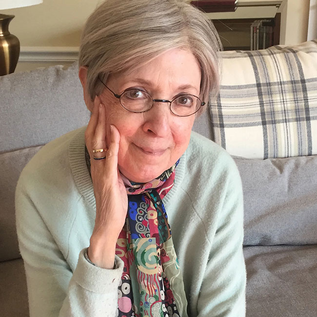 A headshot of Professor Emerita Susan Gubar, who wears a gray sweater and black wire-framed glasses.